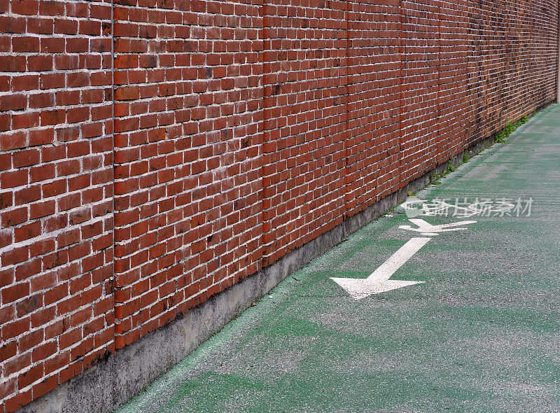 一堵砖墙旁边的自行车线标志