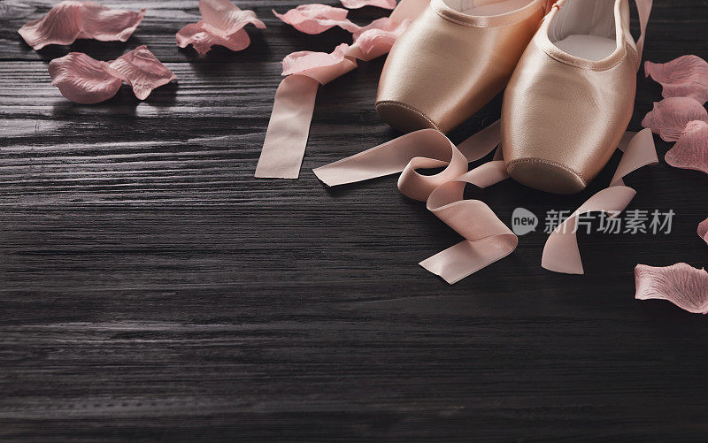 粉红色芭蕾舞尖头鞋上的黑色木材背景