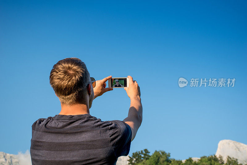 一名年轻人在斯洛文尼亚阿尔卑斯山的克朗山边自拍