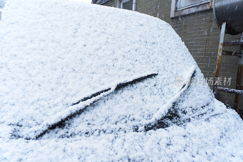 汽车的挡风玻璃上覆盖着雪