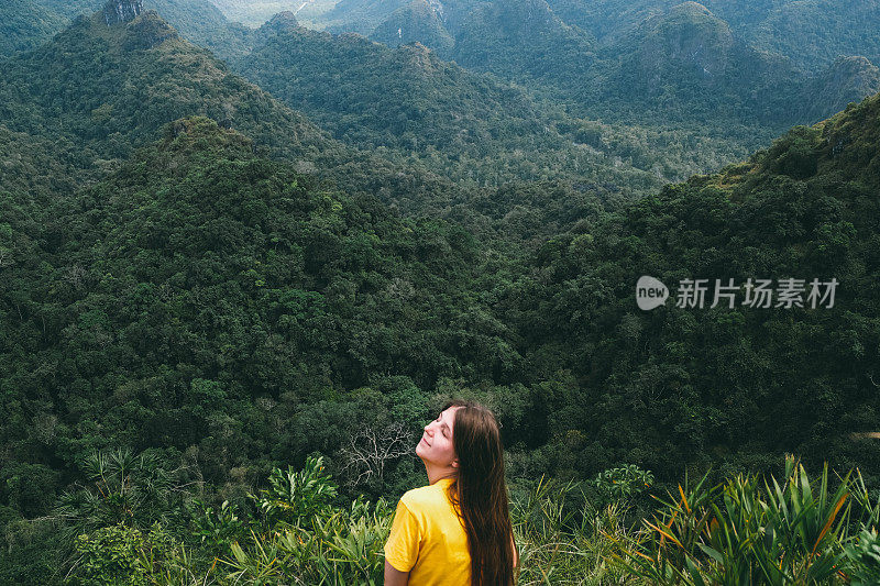 一名女子在山顶休息，欣赏越南吉巴岛的丛林景色