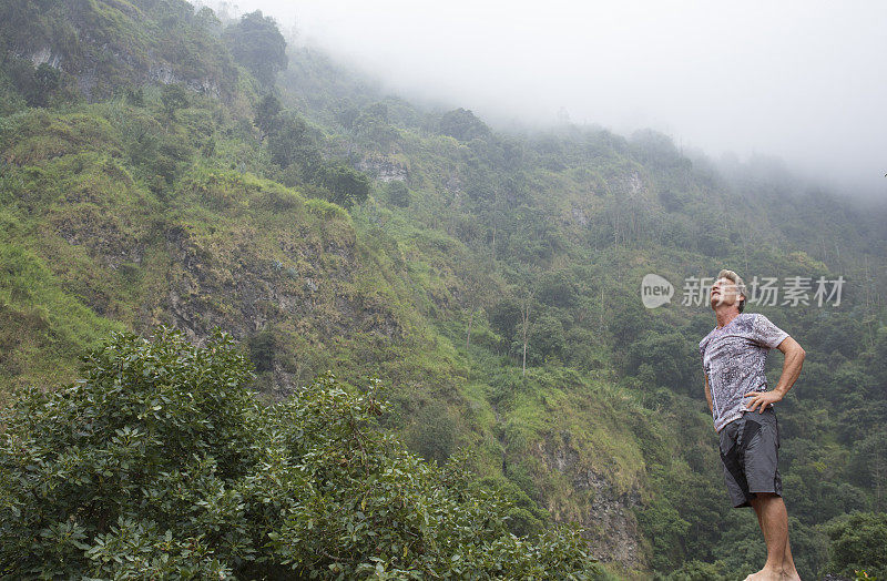 人类欣赏火山两侧的雨林