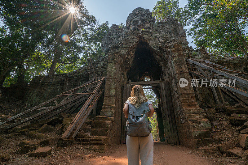 旅游女游客站在寺庙复杂的大门前仰望上面的雕塑，人们发现探索的概念