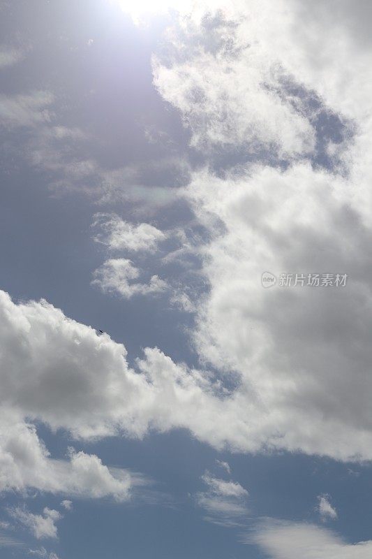 蓝色天空映衬着蓬松、缕缕白云的特写