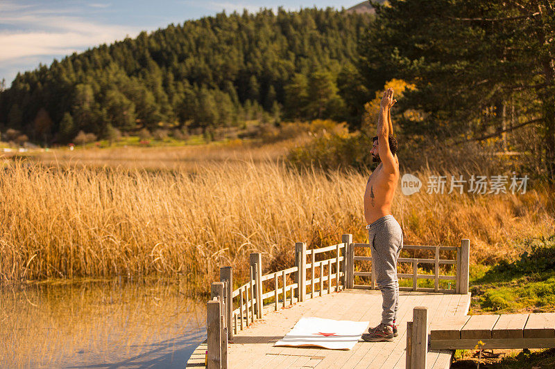 年轻人在大自然中做瑜伽锻炼，在湖边