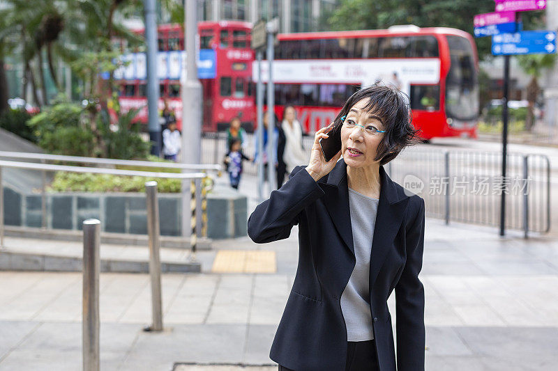 自信的亚洲女商人使用手机