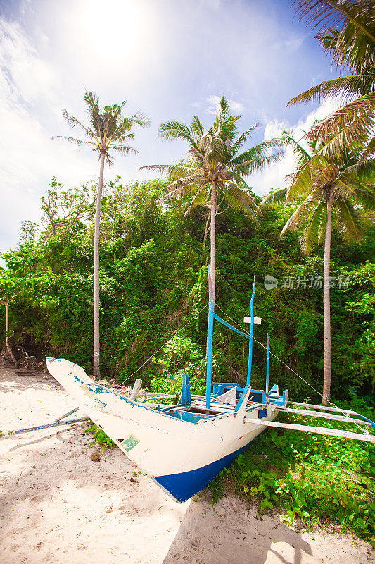 菲律宾长滩岛棕榈树之间的一艘菲律宾船