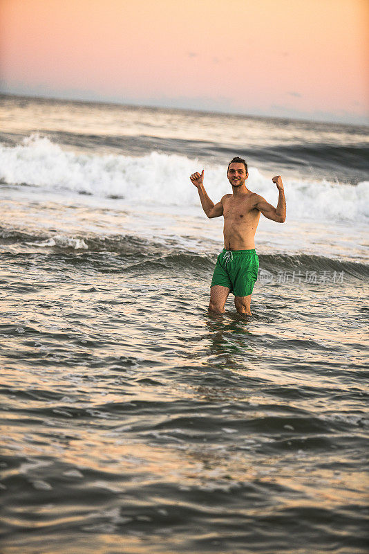 日落时分，一个年轻人在长岛的海里游泳