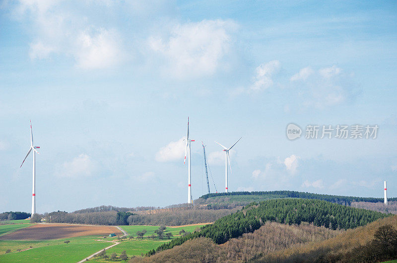 风力涡轮机与起重机在丘陵景观