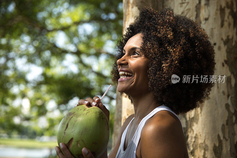 一个巴西女人在公园里喝椰子汁