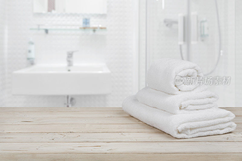 模糊的浴室内部背景和白色温泉浴巾上的木材