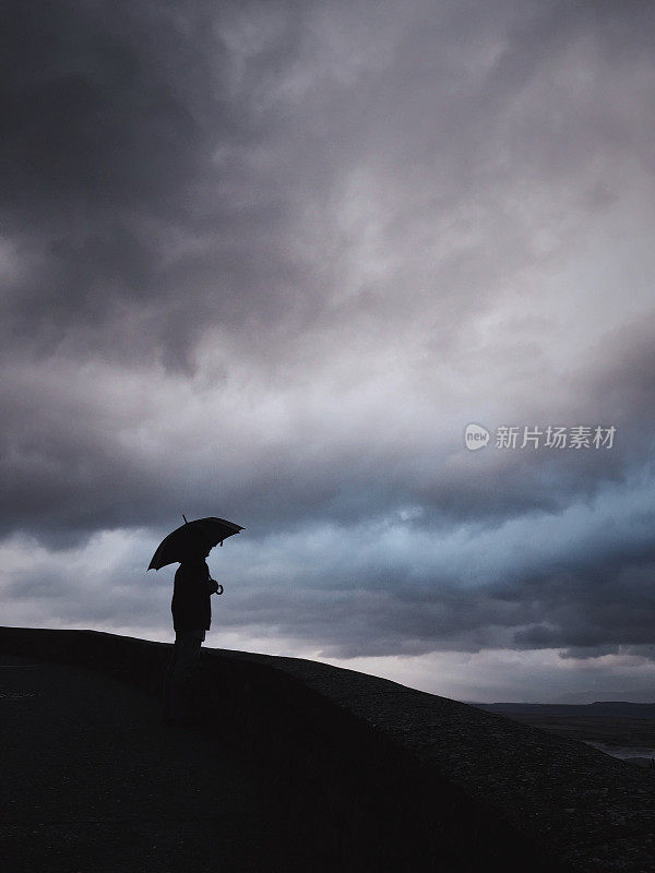 人对着暴风雨的天空。