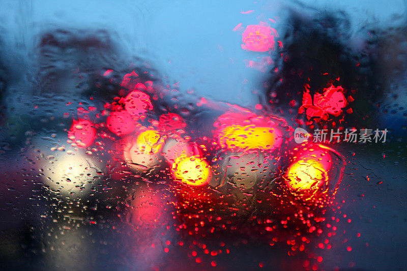 夜间车辆行驶时，雨点落在挡风玻璃上