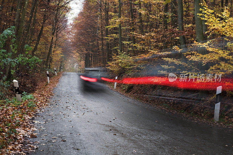 汽车在秋天的森林道路上经过