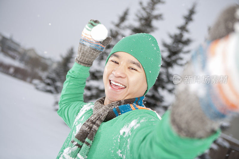 微笑的亚洲人扔雪球