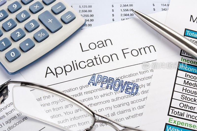 批准的贷款申请表连同钢笔、计算器
