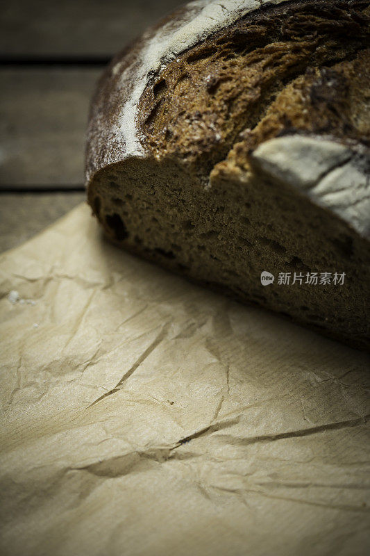 新鲜烘烤的自制黑麦面包在木制的背景