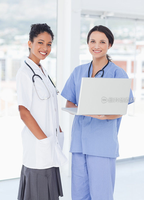 微笑的医疗队站在一起，还有一台笔记本电脑