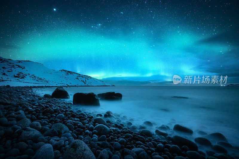 神奇的北极光。俄罗斯捷里别尔卡的北极光。星空，极地的光和云。夜冬山水以极光，海与石在模糊的水，雪山。旅行
