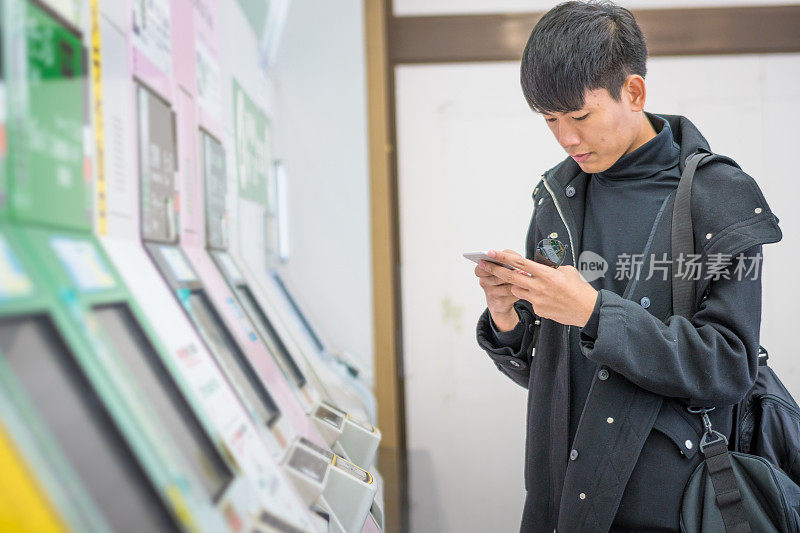 年轻的亚洲男子和日本朋友寻找旅游地点使用手机和花时间在亚洲旅行