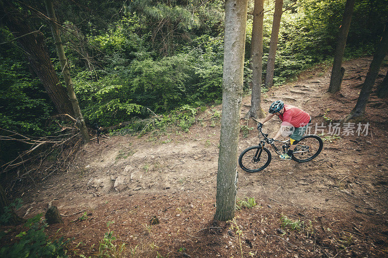 山地自行车手在森林的土路上骑自行车