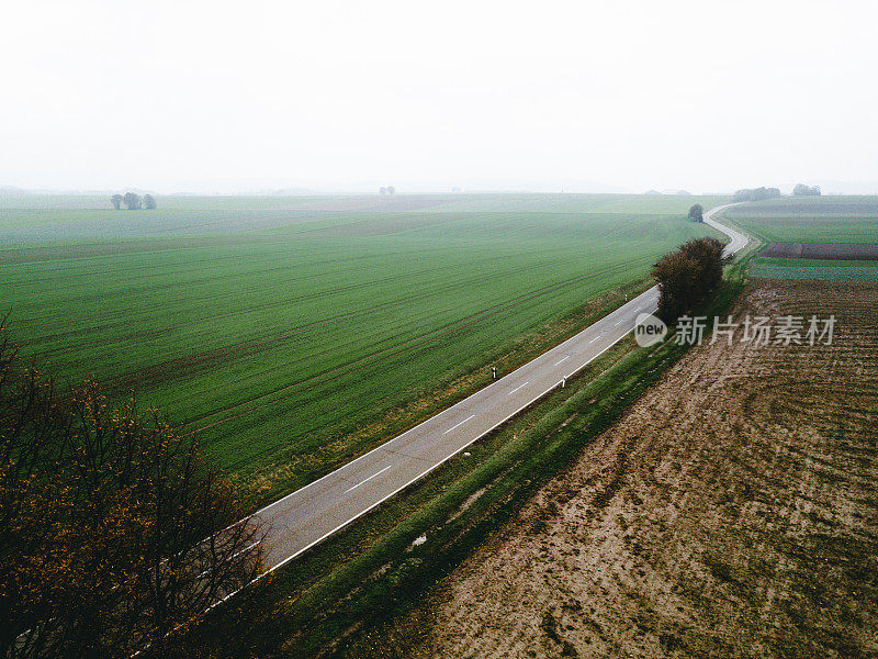 德国雾蒙蒙的道路和五彩缤纷的田野鸟瞰图