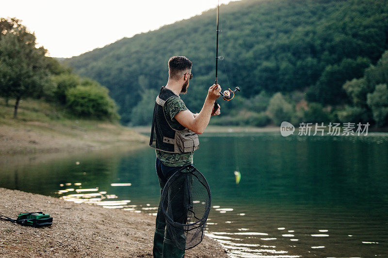 渔夫站在河边，拿着钓竿