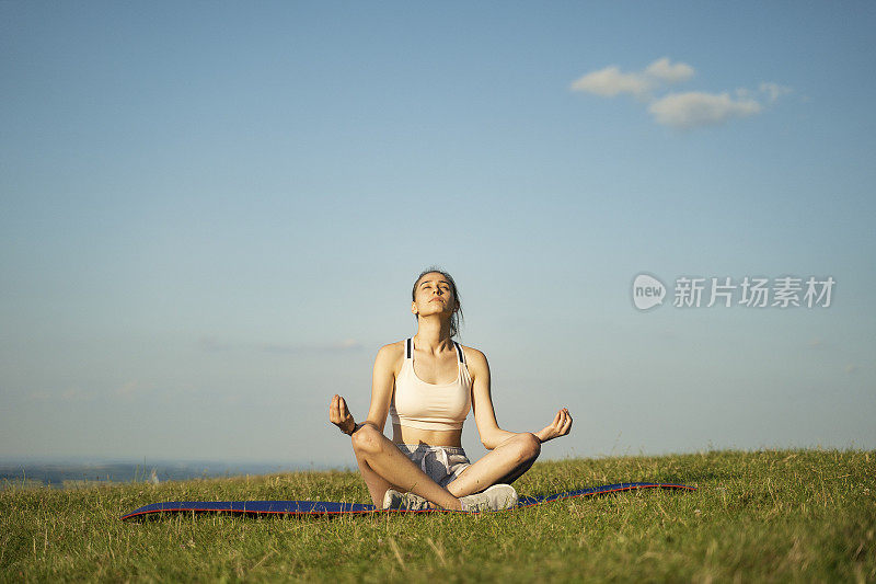 青少年。美丽的少女做瑜伽练习户外的大自然。莲花坐