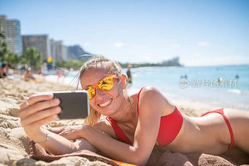 年轻女子在檀香山美丽的海滩自拍照片，夏威夷，美国