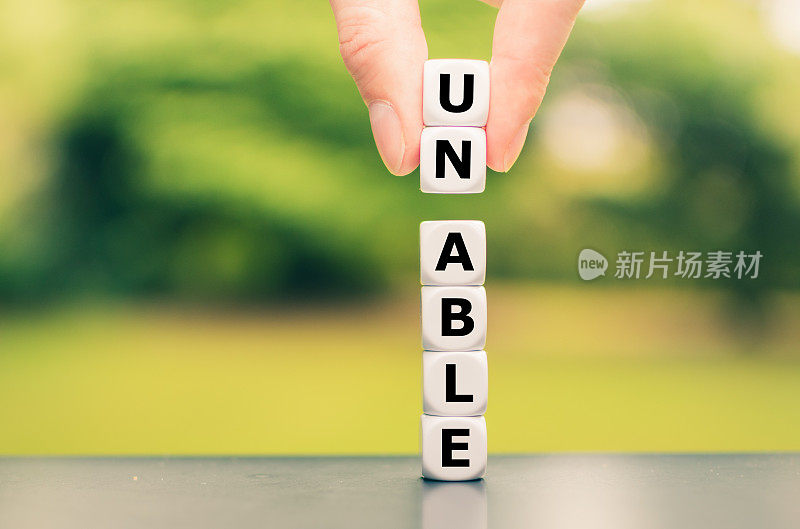 用骰子组成单词“UNABLE”，用两根手指举起字母“UN”，将单词变成“ABLE”。