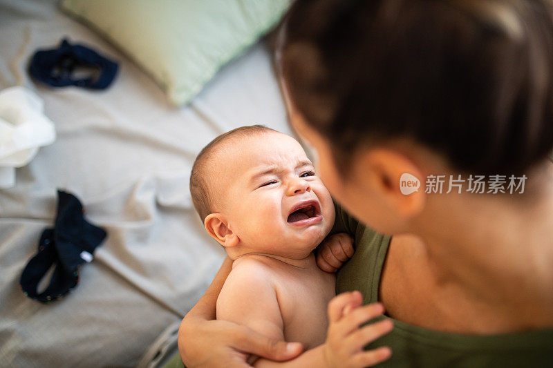 伤心的小男孩在妈妈的怀里哭泣