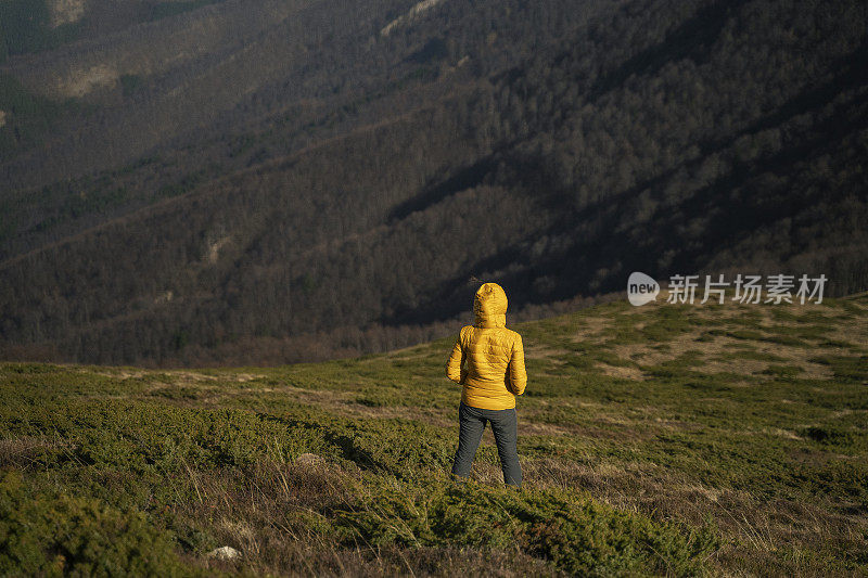 回归自然。独自旅行，俯瞰美丽的全景。一个快乐的年轻女性游客在自然。