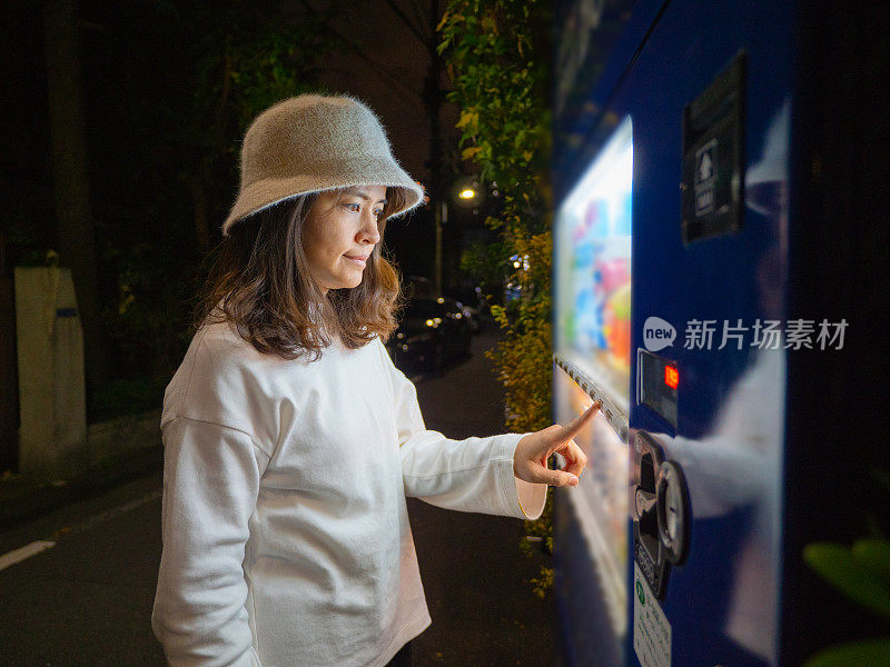 亚洲女人选择一些饮料在自动售货机