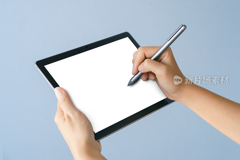 一个女人的手拿着一支笔指着平板电脑的屏幕