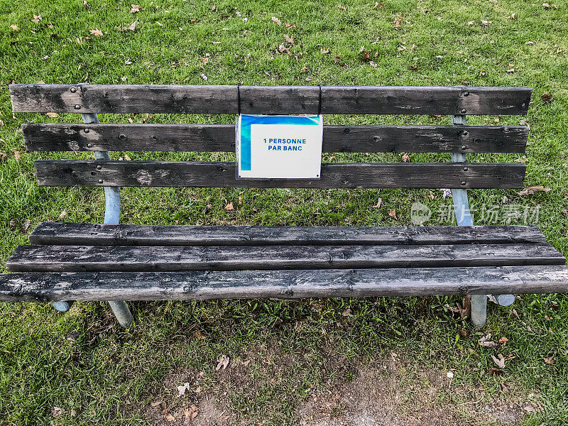 公园里的公共长椅，上面写着每张长椅一人一名