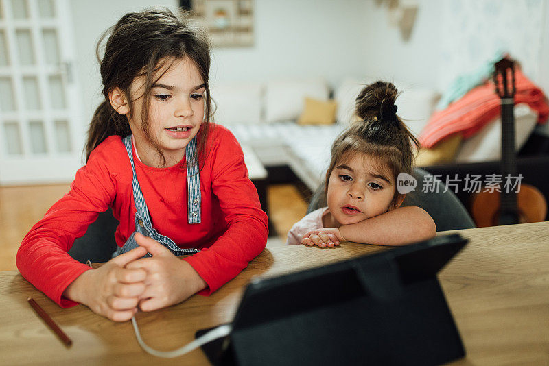 两个女孩在用平板电脑学习