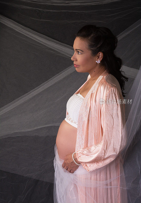 怀孕的加拿大土著妇女穿着桃缎长袍覆盖白色织物。