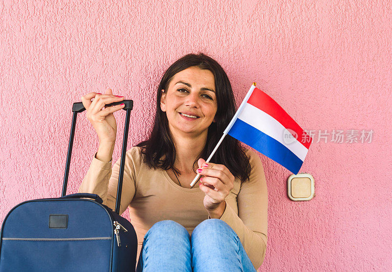 拿着旅行袋和荷兰国旗的女人