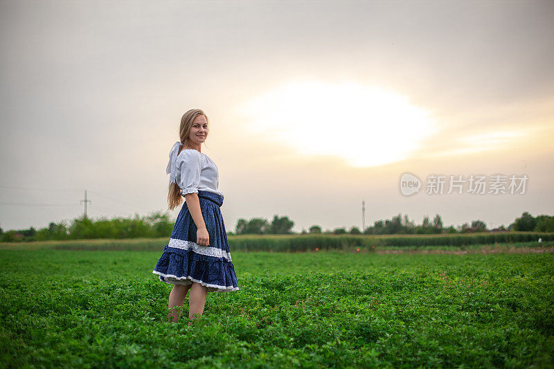 站在三叶草地里的金发女孩