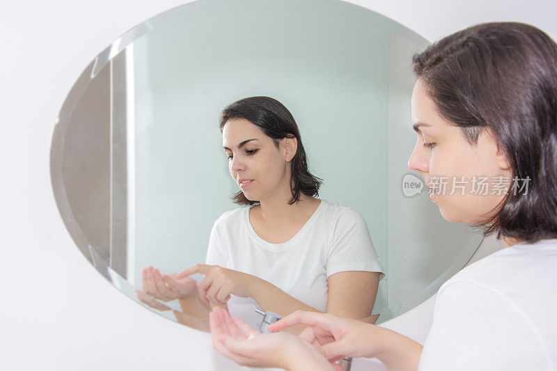 一个女人在镜子前擦面霜