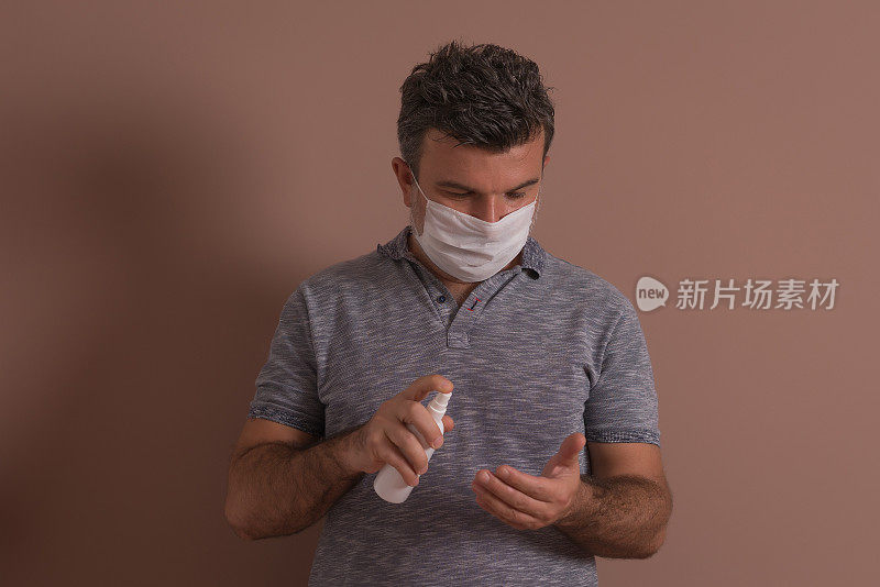 男子用医用消毒液消毒手以保护病毒。