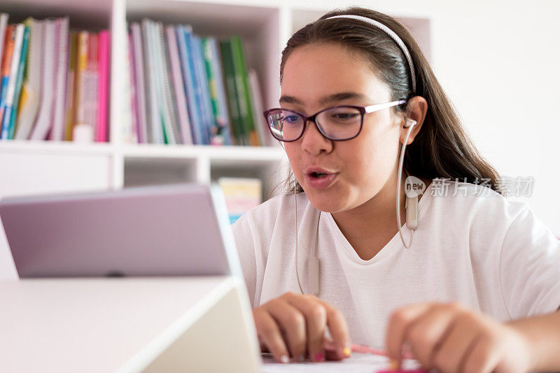 一个女孩正在学习平板电脑和谈话老师在家教育和远程学习