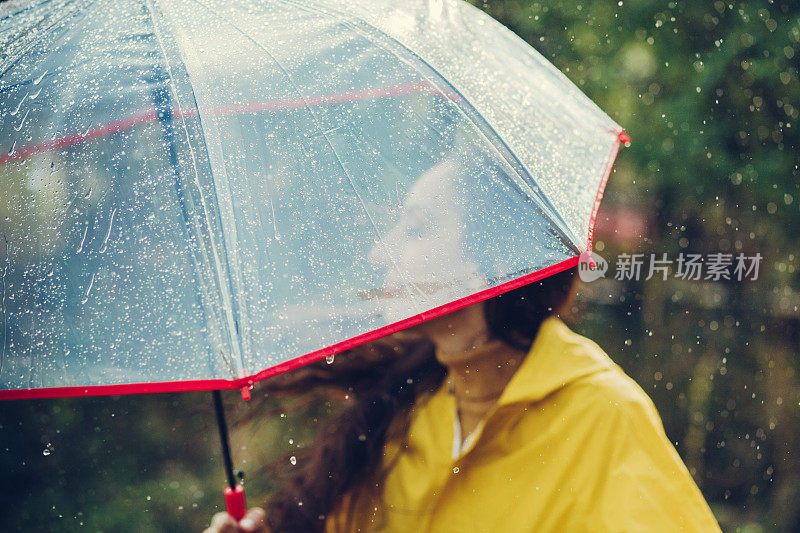 雨中快乐的女孩站在外面