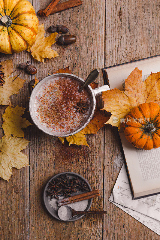 秋天的静物杯可可和彩色的干树叶在木板上
