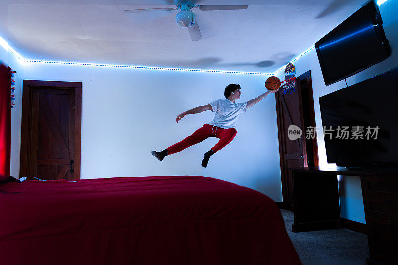 十几岁的孩子在卧室门上的篮子里跳球