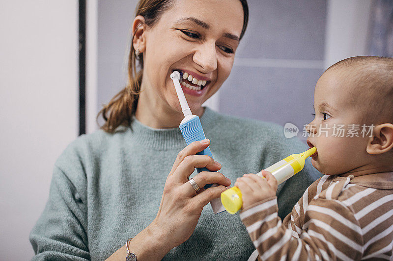 快乐的妈妈教她的儿子刷牙