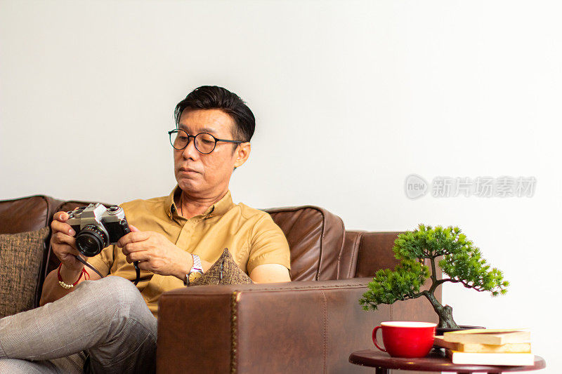 亚洲男人小心他的古董相机