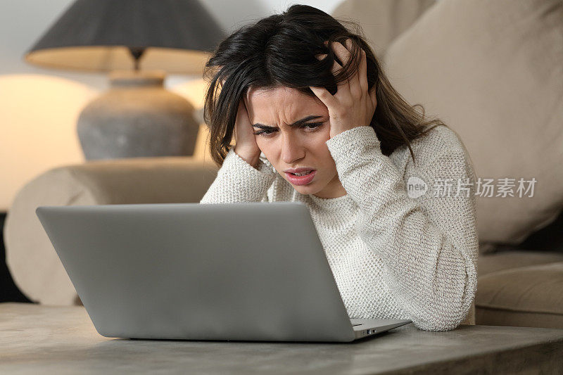 绝望的女人在电脑上查看坏消息