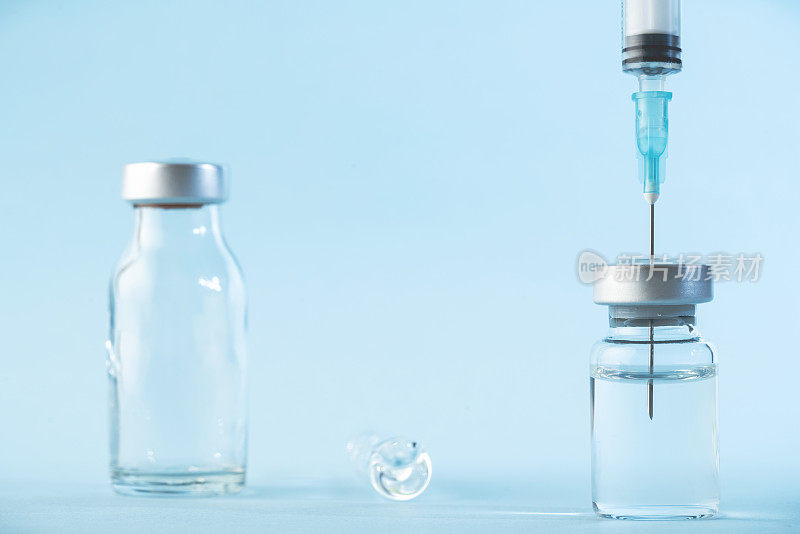 注射器和疫苗的蓝色背景照片