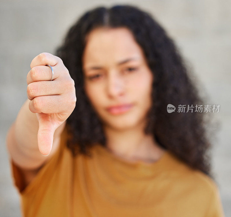 一名年轻女子站在外面，拇指朝下